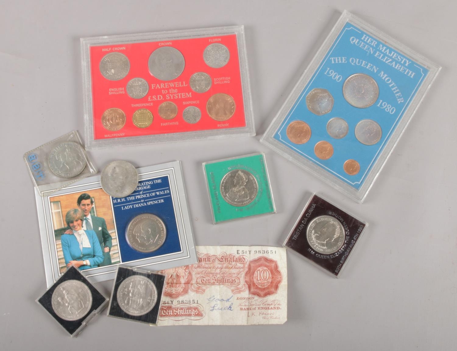 A collection of British coinage. Includes ten shilling note, Five Shilling coins, cased sets etc.