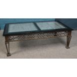 A rectangular metal frame coffee table, with painted top and glass inserts. Height: 42cm, Width:
