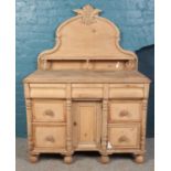 A Victorian pine sideboard with carved and shaped back. Height 158cm, Width 116cm, Depth 60cm.