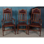 A set of six dark oak and leatherette studded dining chairs, including two carvers.