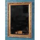 A gilt framed, bevel edge mirror, with floral and beaded decoration. Size of mirror including frame: