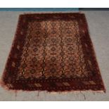 A rectangular red ground rug, with geometric design. 190cm x 130cm. Frayed to corners.