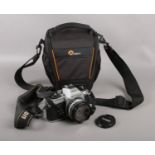 A Nikon FG-20 SLR camera with Nikon Series E 50mm lens. In soft carry case.