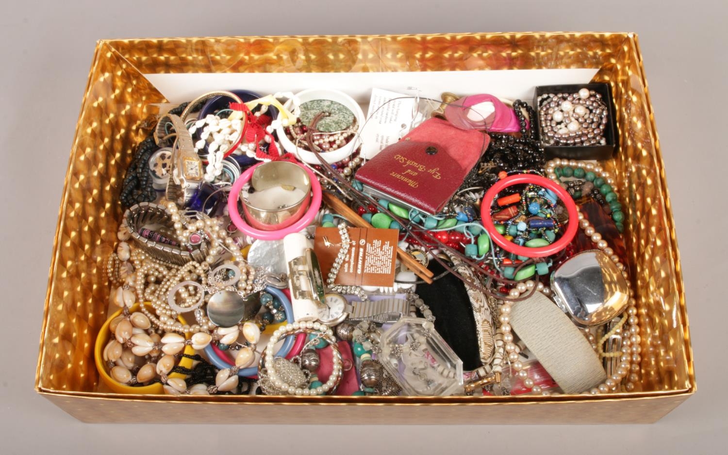 A large box of assorted costume jewellery. To include necklaces, bracelets and dress watches etc.