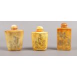 Three Oriental bone snuff bottles, all with stopper spoons.