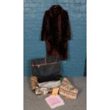 A suitcase of assorted linens/textiles and a ladies fur coat. Vintage tablecloths, napkins, table