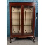 A Victorian mahogany china cabinet raised on ball and claw feet.