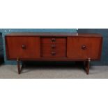 A teak sideboard with sliding doors and central drawers.