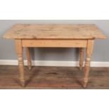 A rectangular pine kitchen table, on turned legs. Height: 75cm, Width: 61cm, Depth: 61cm.