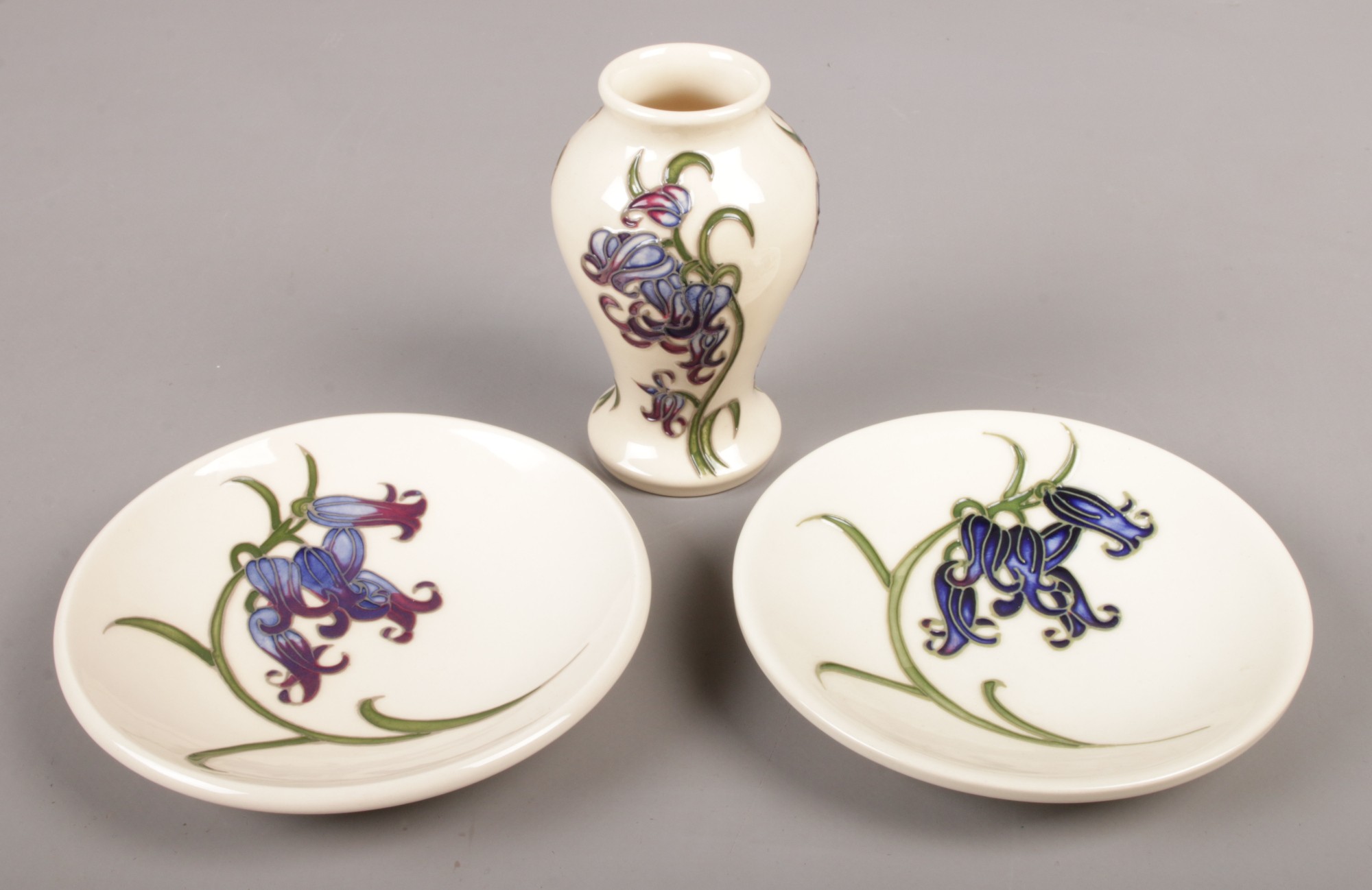 Three pieces of Moorcroft ceramics in the Bluebell design. Includes a small baluster shaped vase and