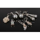 A collection of silver jewellery. Three pairs of drop earrings and two pendants.