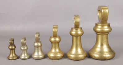 Six graduated bell-shaped brass weights, 1lb - 14lbs, bearing different marks to the base.
