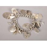 A silver charm bracelet with heart shaped clasp and mostly silver charms. 102g.