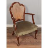 An Art Deco walnut bedroom armchair with bergere back rest.