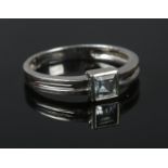 A 9ct white gold ring set with a square cut pale blue stone. Size O. 2.09g.