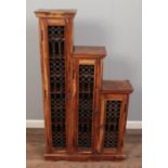 A stepped Indonesian hardwood three door unit with ironwork mesh and shelves. H:132cm W:74cm D:24cm