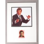 A mounted autograph display card of Roger Moore as James Bond. Signed. Height: 41.5cm, Width: 30cm.