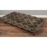 A large sofology footstool, upholstered in brown and black fabric. Height: 32cm, Width: 137cm,