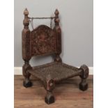A tribal low chair with carved back and leather strung seat and top rail. H:77cm W:47cm D: 44.5cm.