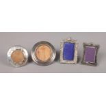 A collection of four miniature silver photo frames. Two assayed for Birmingham, G & C Ltd, the other