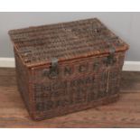 A large wicker basket with metal mounts. Stencilled NCS to the front. (51cm x 75cm)