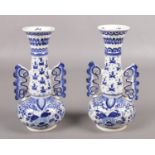 A pair of twin handled delft vases, with floral and clover decoration. Stamped to the bottom K110,