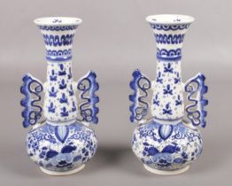 A pair of twin handled delft vases, with floral and clover decoration. Stamped to the bottom K110,