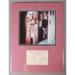 A mounted photograph and postcard, signed by Carry On actors Sid James and Kenneth Williams, Bernard