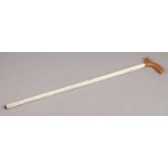A walking stick in the form of vertebrae, with wooden handle. 89cm long. Crack to one vertebra.