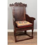A 19th century oak chair with panelled back and decoratively carved back. Comes with tapestry