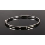 A 9ct white gold bangle set with five small diamonds. 5.03g.