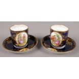 Two Vienna porcelain cups and saucers. In cobalt blue and gilt with hand painted classical panels.