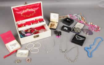 A quantity of costume jewellery. Brooches, necklaces, beads etc to include a jewellery box.