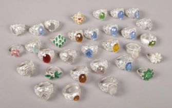 Thirty one white metal rings, all set with coloured stones.