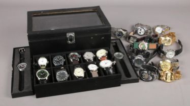 A large collection of quartz wristwatches, to include twenty contained within a display case.