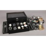 A large collection of quartz wristwatches, to include twenty contained within a display case.