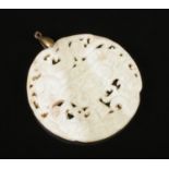A Chinese jade coloured bi disc/pendant with bull decoration. Diameter 6.5cm.