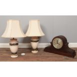 A pair of ceramic table lamps and shades along with a dome shaped mantel clock.