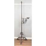 A large wrought iron candlestick, with branched arm and scrolled tripod base. Height: 224cm high.