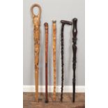 Five walking sticks, to include stick depicting elephants and giraffes, along with a tribal and