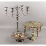 Four pieces of metalwares. Including brass trivet, large silver plated candelabra, ornate