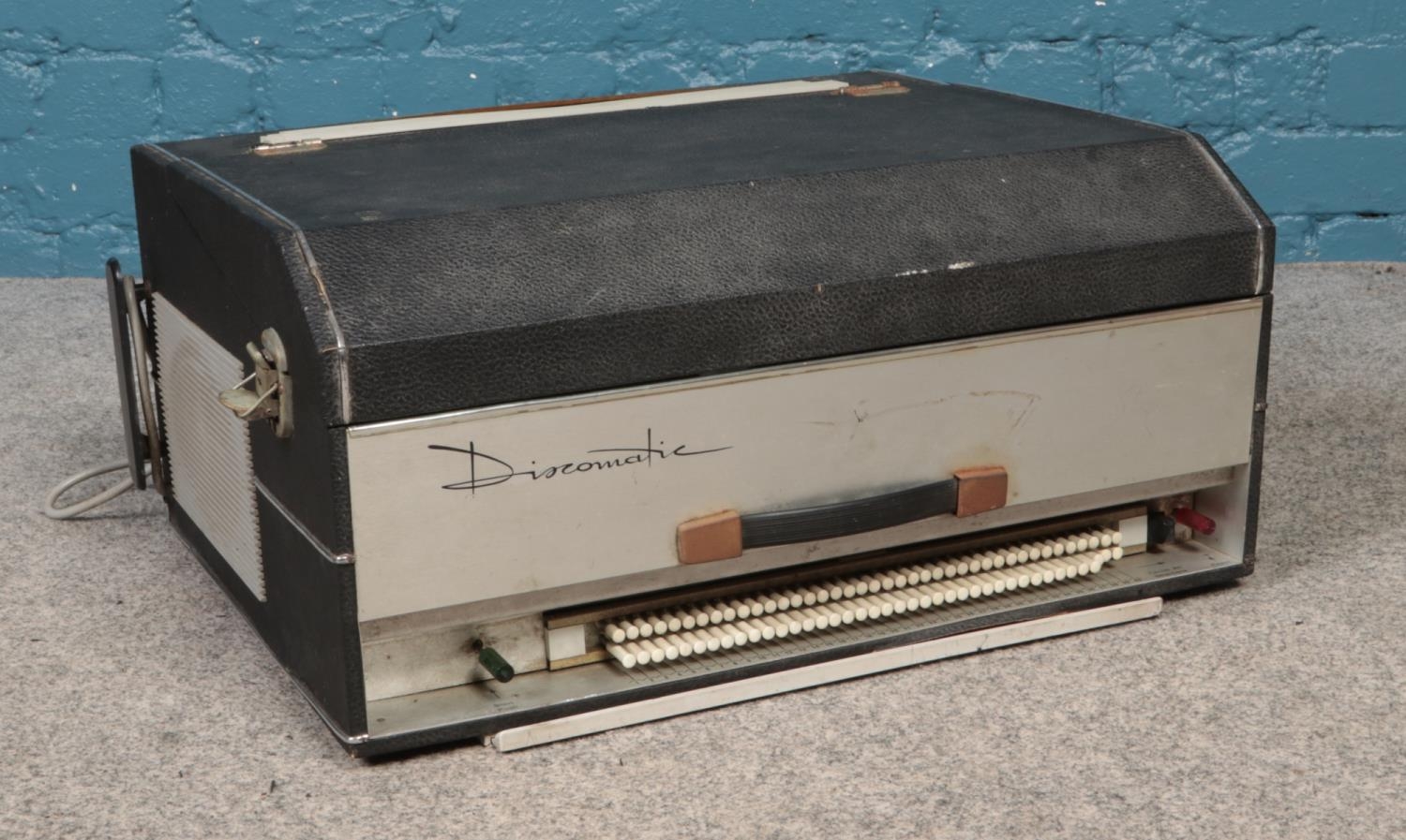 A Discomatic c1960's portable jukebox. Comes with facility to hold forty single vinyl records.