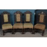 A set of four carved oak gothic revival dining chair with green velvet upholstery.