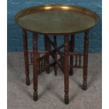 An Indian brass top folding table.