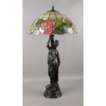 A large table lamp with Grecian female figure and Tiffany style shade. H: 80cm. Will need a plug.