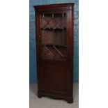 A Victorian mahogany corner cabinet, with astragal glazed panel and hinged lower drawer. Height: