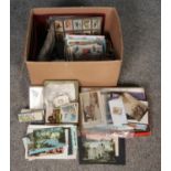 A box of postcards, cigarette cards (some in albums), stamps and early 20th Century ephemera.