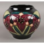 A Moorcroft bulbous vase, with blue ground depicting red poinsettia. Stamped to the base with the