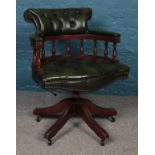 A modern deep buttoned and studded green leather Captain's swivel chair, raised on casters. Some