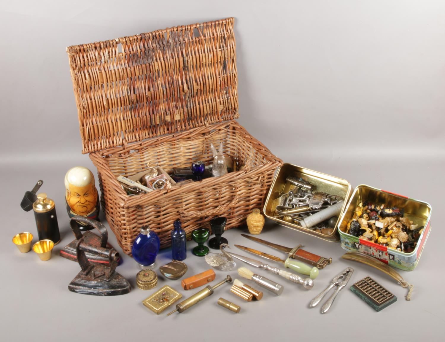 A wicker basket containing an extremely large assortment of collectables. To include letter openers,